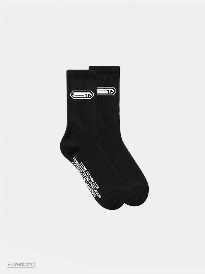 Paar schwarze gerippte Crew-Socken mit weißem Stone-Techno-Logo am Schaft. Auf der Außenseite verläuft ein weißer Schriftzug mit dem Text „STONE TECHNO 2026 PRESENTED BY THE THIRD ROOM & FOUNDATION ZOLLVEREIN“. Produktdarstellung vor hellem Hintergrund.