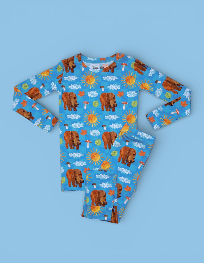 Blue long-sleeve pajama set with brown bears, suns, clouds, mushrooms, and leaves pattern throughout.