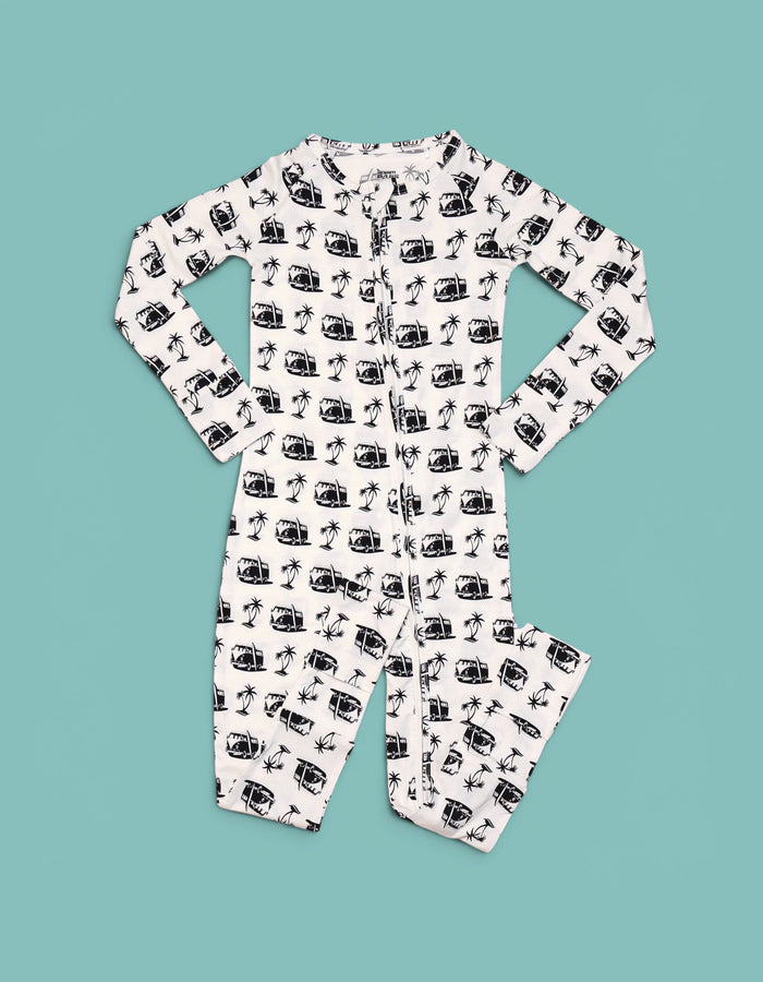 Cream romper with black vintage camera and palm tree print throughout, long sleeves, button front closure.