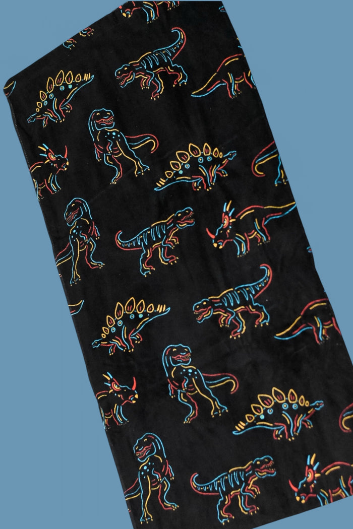 Black towel with neon-outlined dinosaurs in blue, red, and yellow scattered across the fabric.