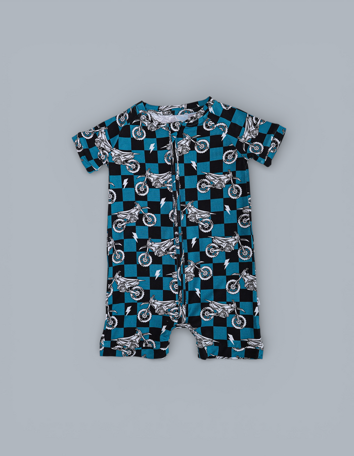 Short-sleeved romper with blue and black checkerboard pattern featuring white motorcycle and lightning bolt prints throughout