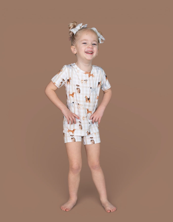 Light blue bow hair clips worn by child in hair, shown on tan background.