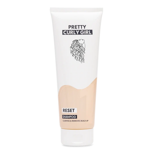 A white squeeze tube of Pretty Curly Girl Reset Shampoo with a beige color-blocked section and black text, centered on a white background.